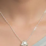 Silver plated necklace with freshwater pearl pendant in minimalist floral setting on chain