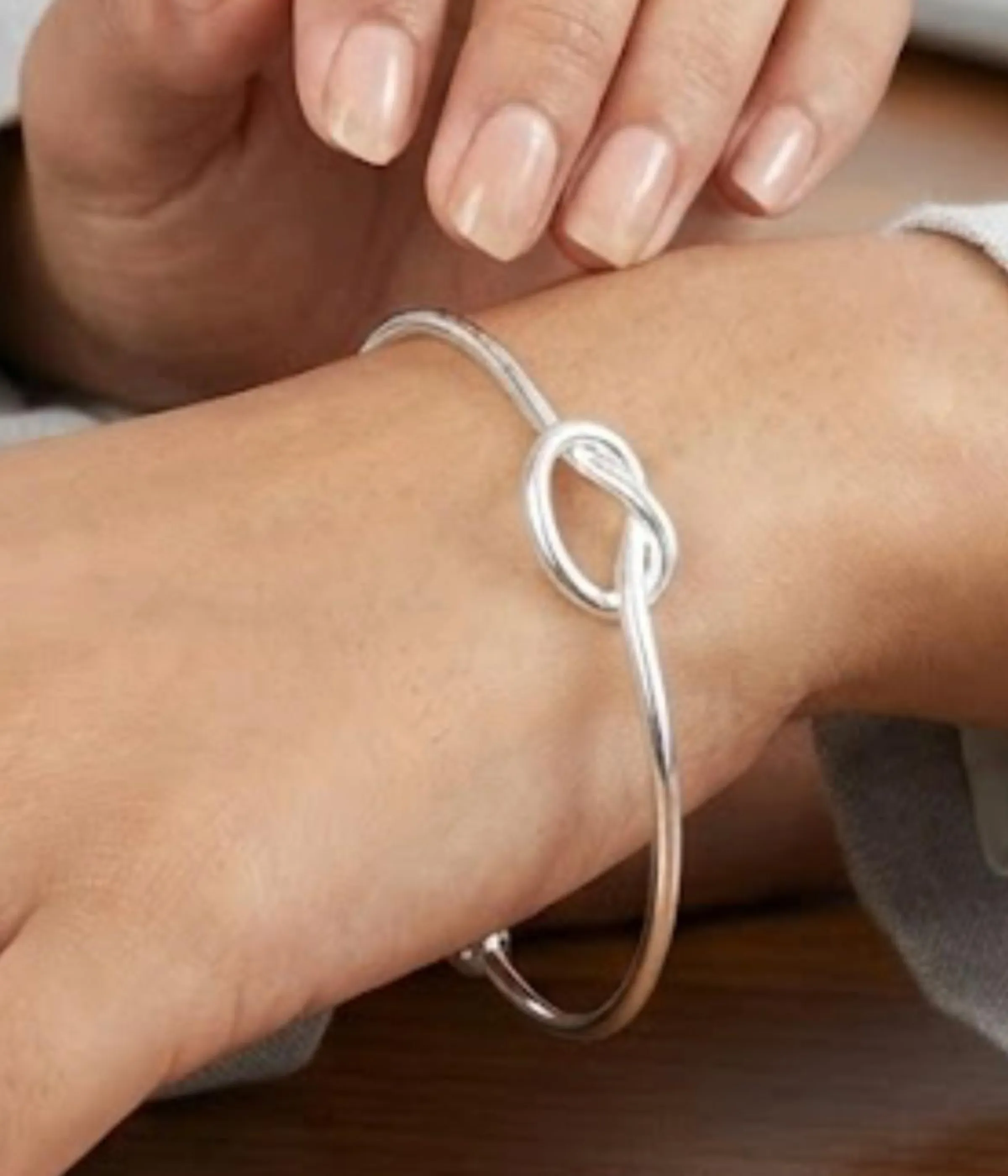 Gemini said A minimalist silver plated heart charm bracelet on a sleek snake chain with an adjustable clasp, displayed on a clean background.