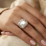 Gemini said A silver-plated statement ring featuring a large, irregular baroque pearl encased in an organic, molten-style vine setting with a high-shine polished finish.