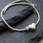 Silver plated snake chain bracelet with polished heart charm and adjustable clasp