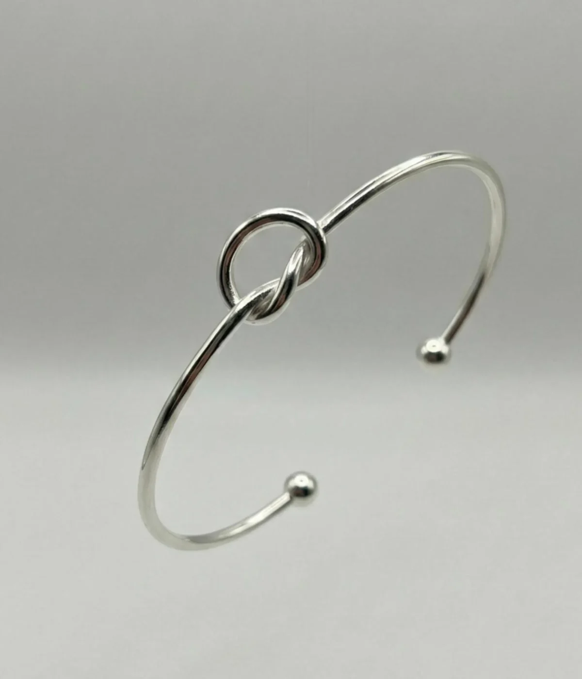 Gemini said A minimalist silver plated heart charm bracelet on a sleek snake chain with an adjustable clasp, displayed on a clean background.