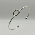 Gemini said A minimalist silver plated heart charm bracelet on a sleek snake chain with an adjustable clasp, displayed on a clean background.