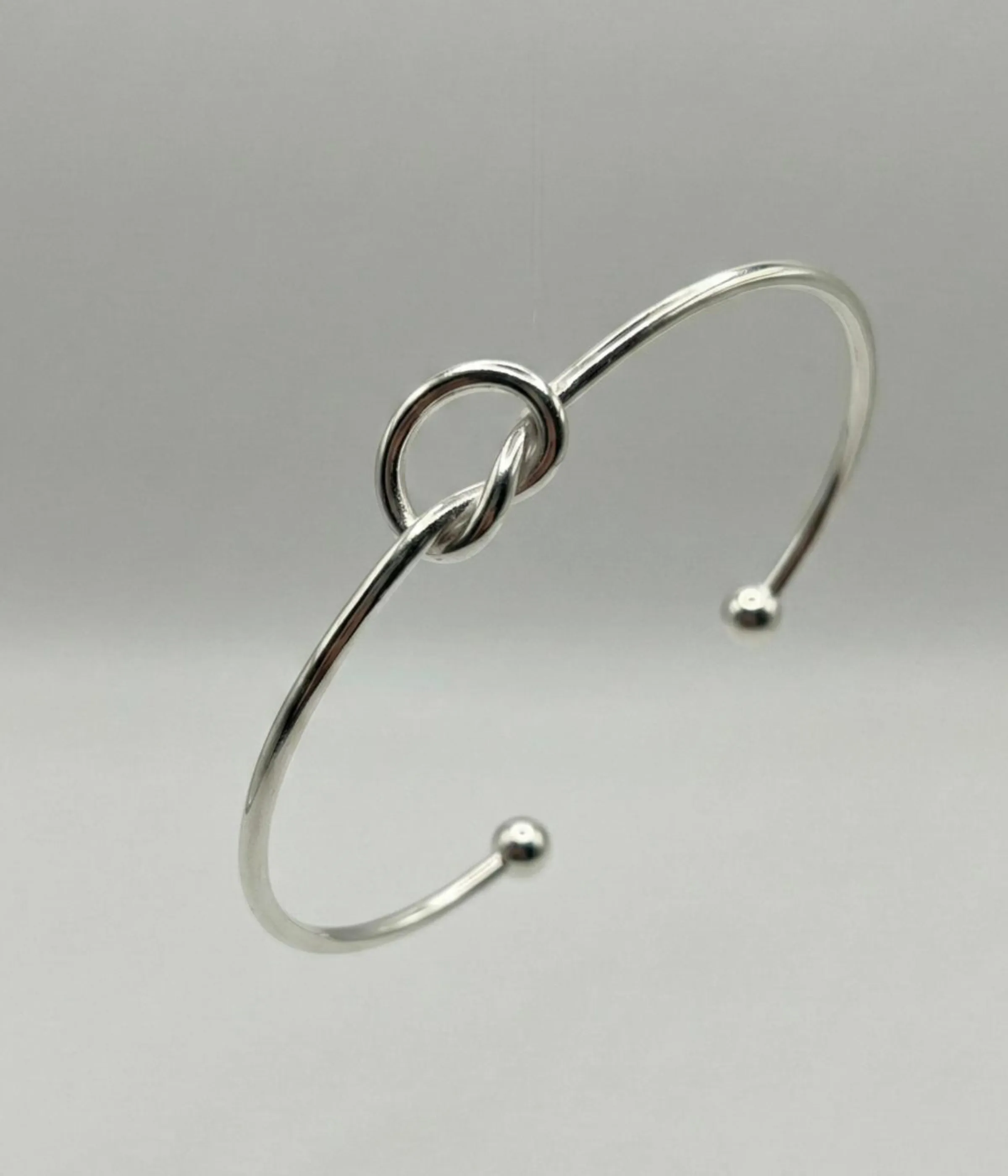 Gemini said A minimalist silver plated heart charm bracelet on a sleek snake chain with an adjustable clasp, displayed on a clean background.