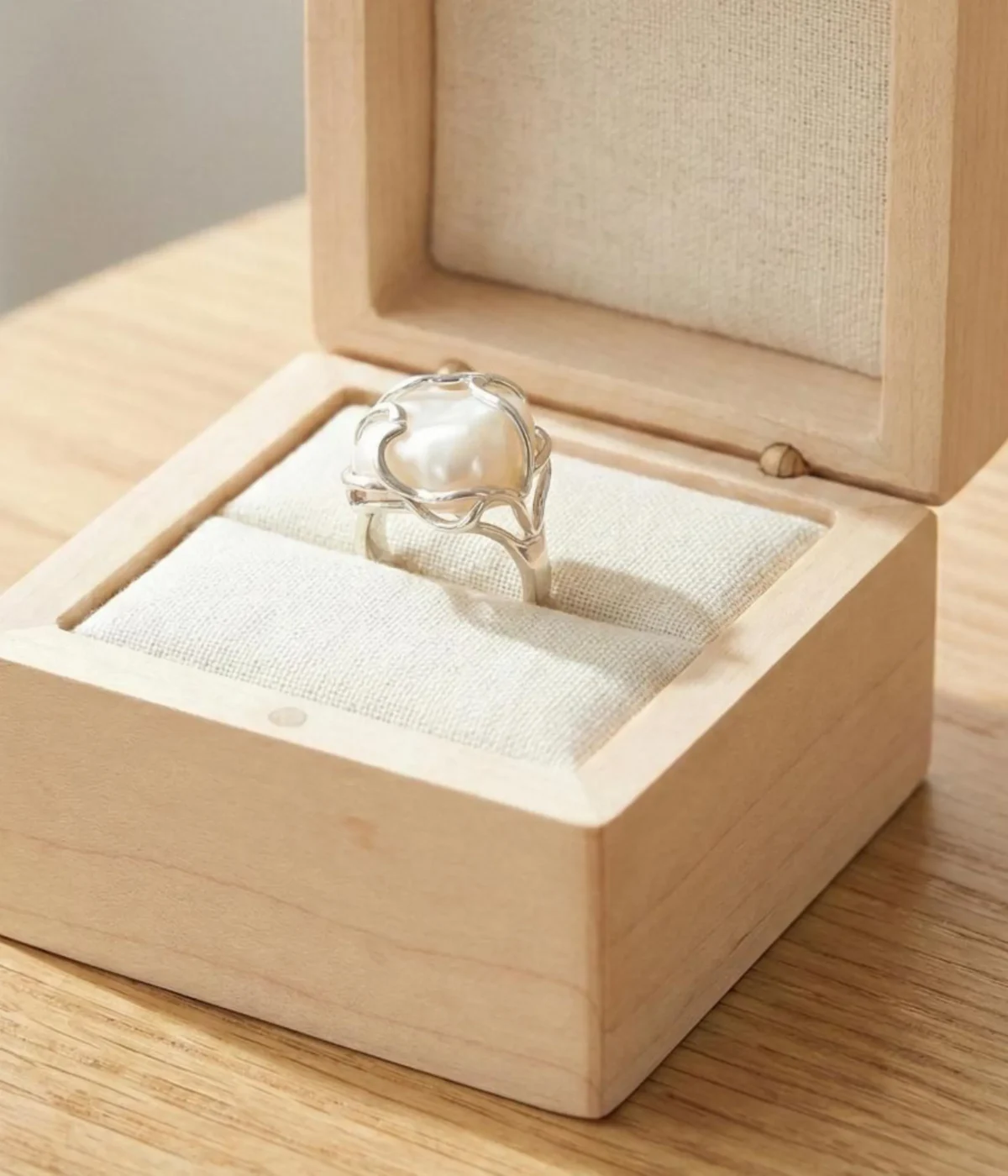 Gemini said A silver-plated statement ring featuring a large, irregular baroque pearl encased in an organic, molten-style vine setting with a high-shine polished finish.